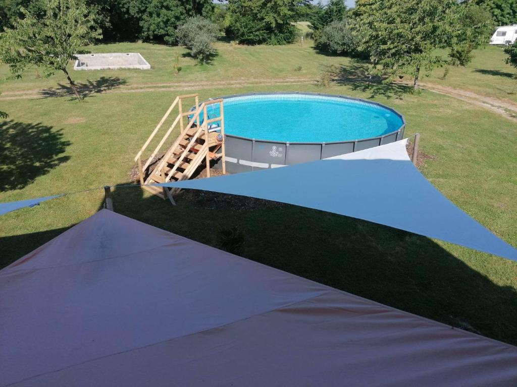 - une vue sur la piscine dans la cour dans l'établissement Pays de Joie - Caravan La Bohème, à Saint-Macoux 9 autres photos