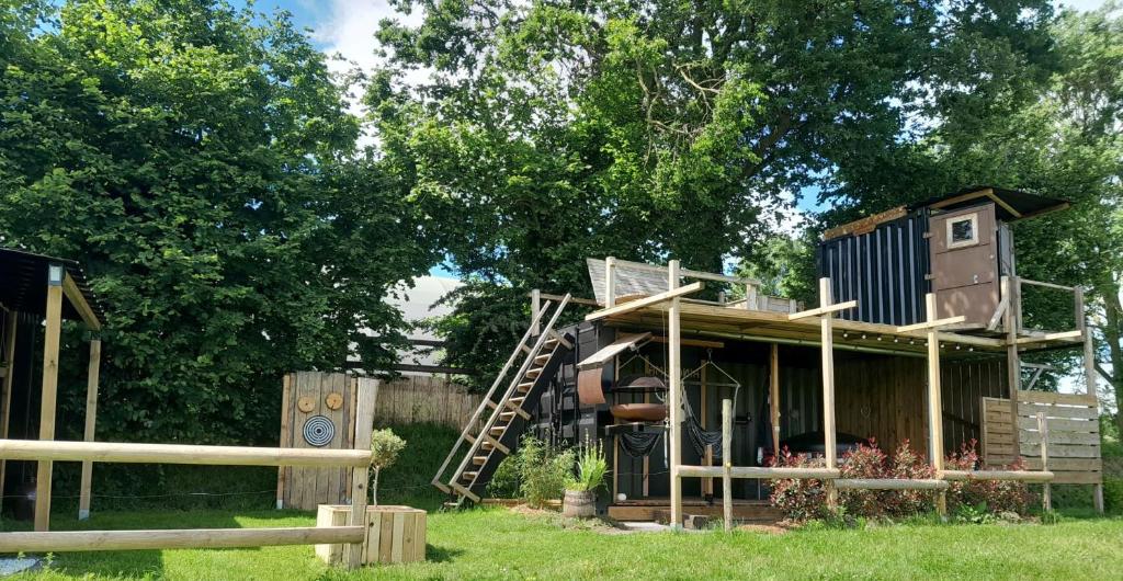 une cabane dans les arbres avec un toboggan et une aire de jeux dans l'établissement amazonia, à Litteau
