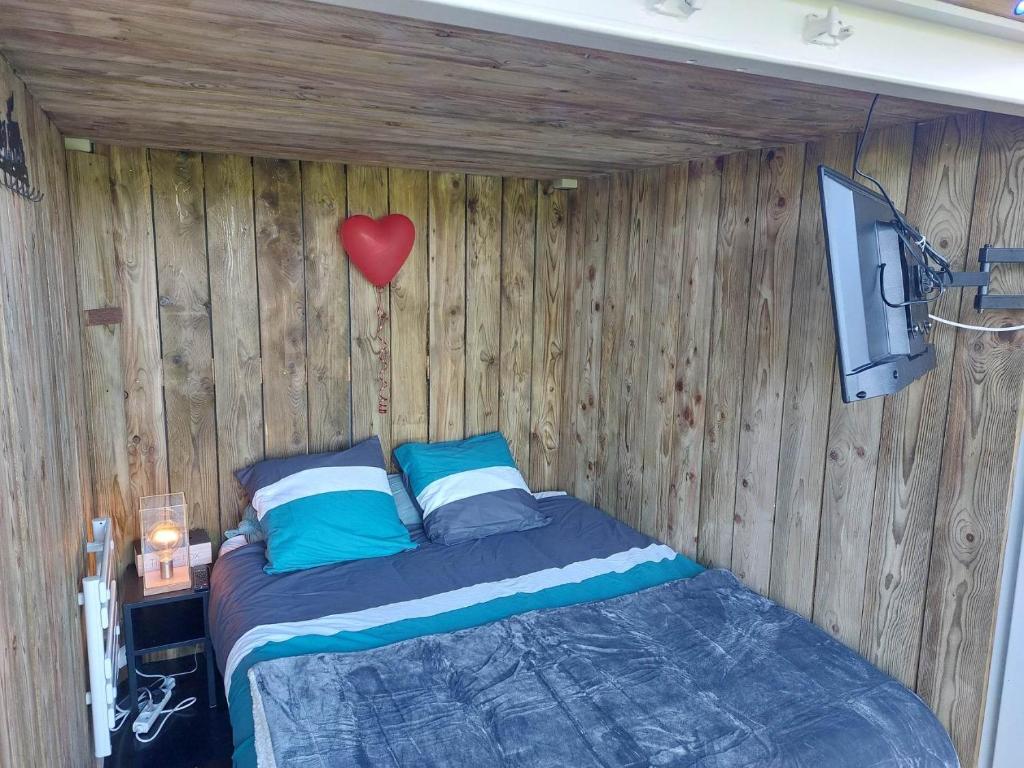 une chambre avec un lit et un ballon en forme de cœur dans l'établissement amazonia, à Litteau