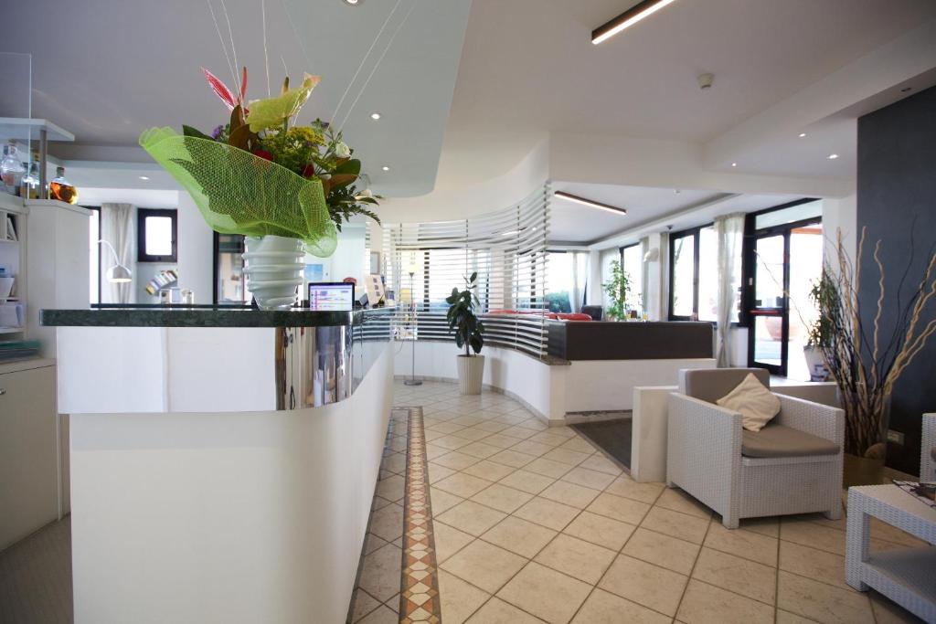 un hall avec un espace d'attente avec des plantes au comptoir dans l'établissement Hotel il Delfino, à San Vincenzo