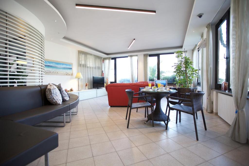 un salon avec un canapé et une table avec des chaises dans l'établissement Hotel il Delfino, à San Vincenzo