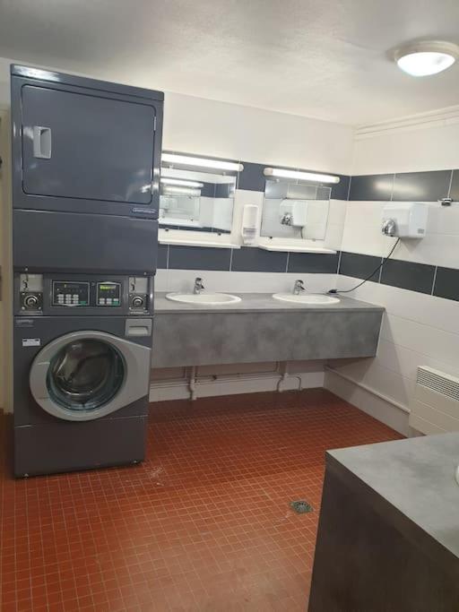 une salle de bain avec une machine à laver et un lavabo dans l'établissement Nuit romantique sur un bateau à Deauville, à Deauville 12 autres photos
