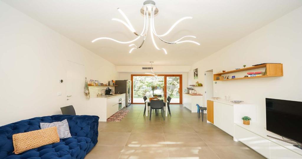 un salon avec un canapé bleu et un lustre dans l'établissement Odegos Villa Aira, à Torre dell'Orso