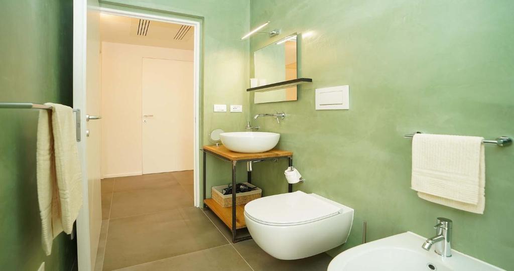 une salle de bain avec des toilettes blanches et un lavabo dans l'établissement Odegos Villa Aira, à Torre dell'Orso