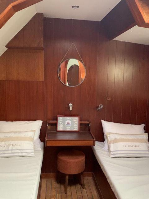 Cette chambre comprend 2 lits et une table sur un bateau. dans l'établissement Valmarelo Maxi Catamaran, à Saint-Philibert