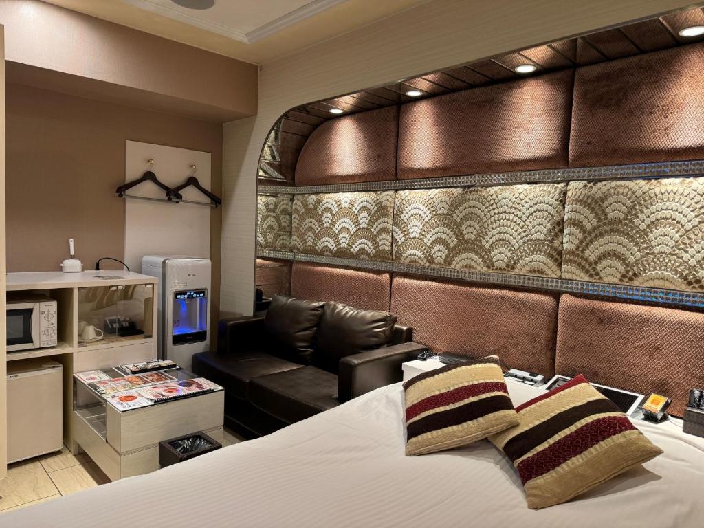 une chambre d'hôtel avec un lit et un canapé dans l'établissement ホテルコスタリゾート飯能, à Hannō