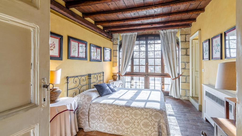 une chambre avec un lit et une grande fenêtre dans l'établissement Il Roseto 10, Emma Villas, à Terruggia 30 autres photos