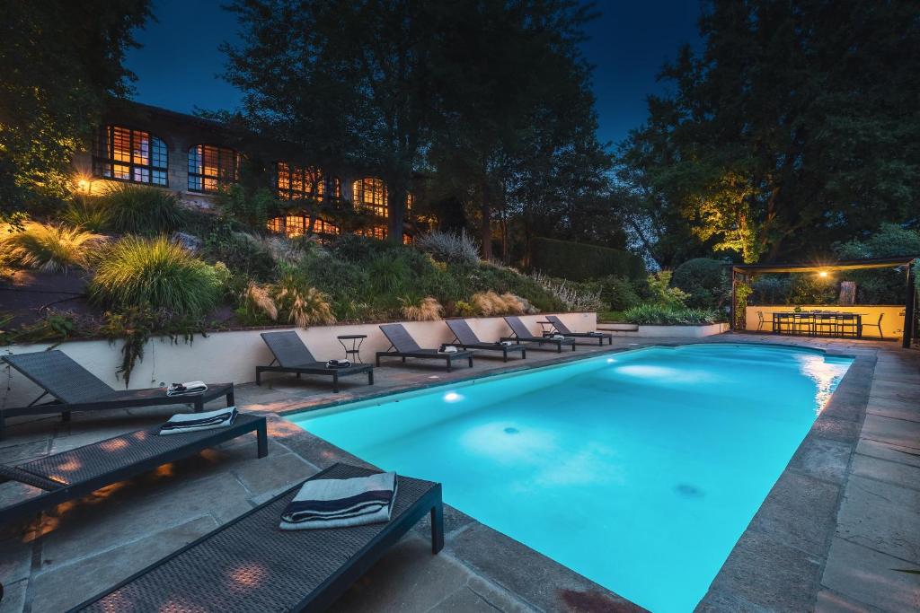 une piscine avec des chaises longues autour la nuit dans l'établissement Il Roseto 10, Emma Villas, à Terruggia