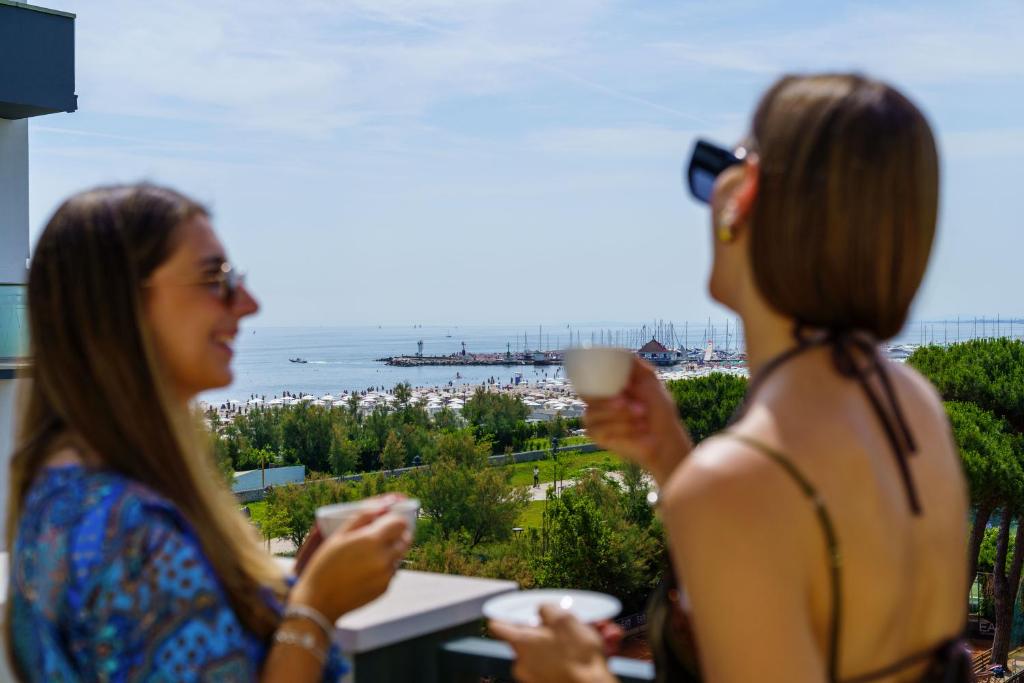 deux femmes parlent et boivent dans des tasses dans l'établissement Brasil Seaview Hotel, à Milano Marittima