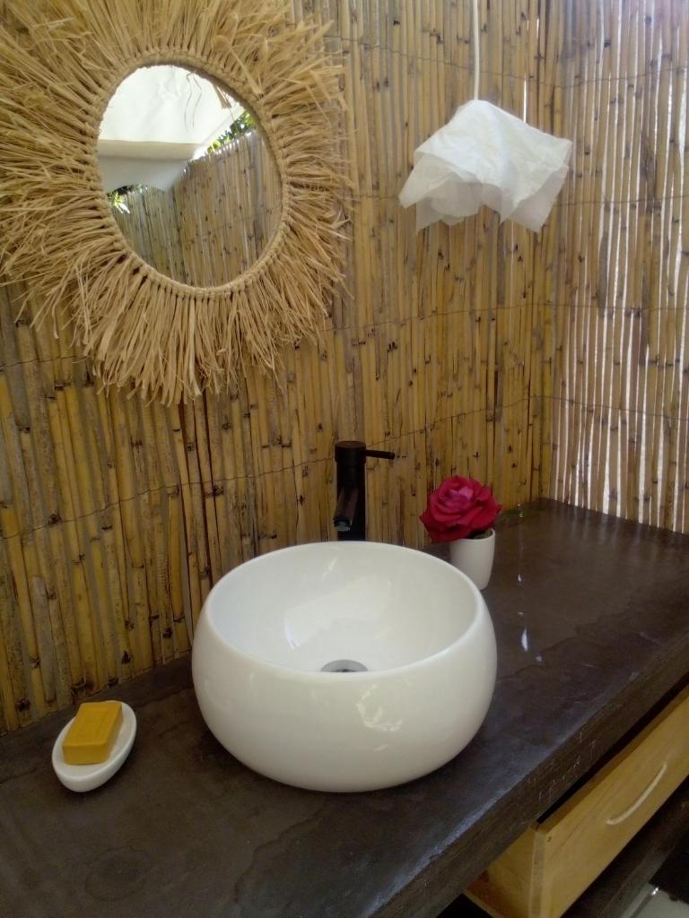 une salle de bain avec un lavabo blanc et un miroir dans l'établissement Glamping at Séraphin's, à Navacelles