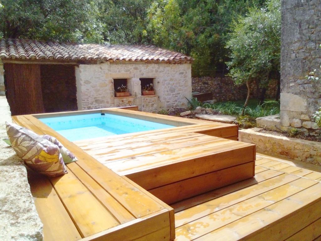 une piscine avec une terrasse en bois à côté d'une maison dans l'établissement Glamping at Séraphin's, à Navacelles