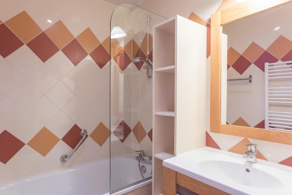 une salle de bain avec un lavabo et une douche dans l'établissement Résidence partenaire Le Schuss, à Val Thorens