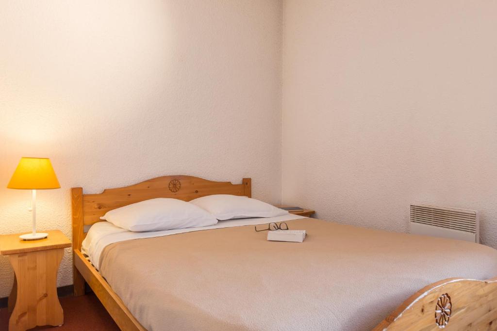 une chambre avec un grand lit avec une lampe et un lit sidx sidx sidx sidx dans l'établissement Résidence partenaire Le Schuss, à Val Thorens