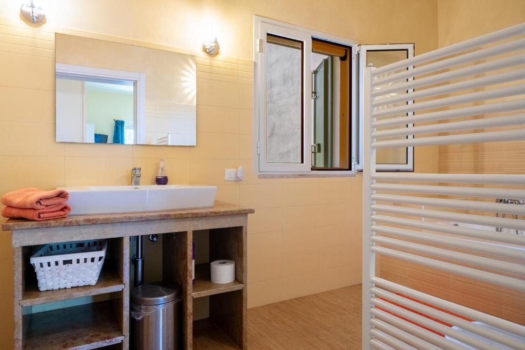 une salle de bain avec un lavabo et un miroir dans l'établissement Casa Rocco, private pool, à Ceglie Messapica