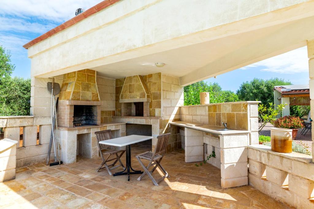 Il dispose d'une terrasse avec une cuisine extérieure dotée d'une table et de chaises. dans l'établissement Casa Rocco, private pool, à Ceglie Messapica
