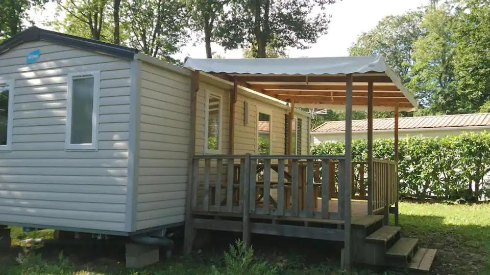 une petite maison avec une terrasse couverte et un kiosque dans l'établissement 45mn de Paris - Beau mobilhome pour famille et travail, à Saint-Chéron