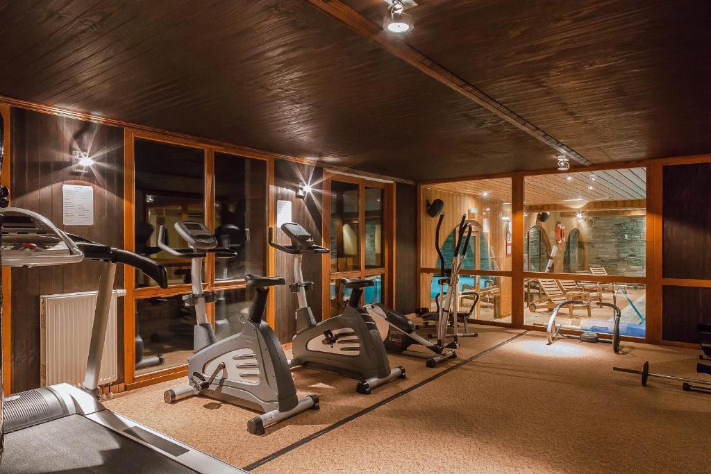 une salle de sport avec plusieurs tapis de course et machines elliptiques dans l'établissement Résidence Les Balcons de Belle Plagne, à Belle Plagne