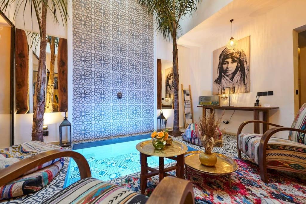 un salon avec une piscine avec des palmiers dans l'établissement Riad Miloud en exclusivité 10 P au cœur de la Médina, à Marrakech