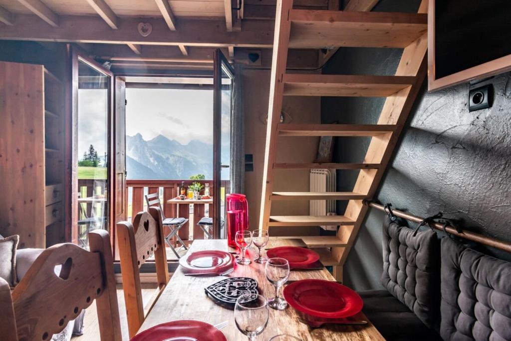 - une table en bois avec des assiettes rouges et des verres à vin dans l'établissement Slow Chalet MtBlanc Soleil Ski-inout Nice View Balcony Elevator Parking, à Manigod