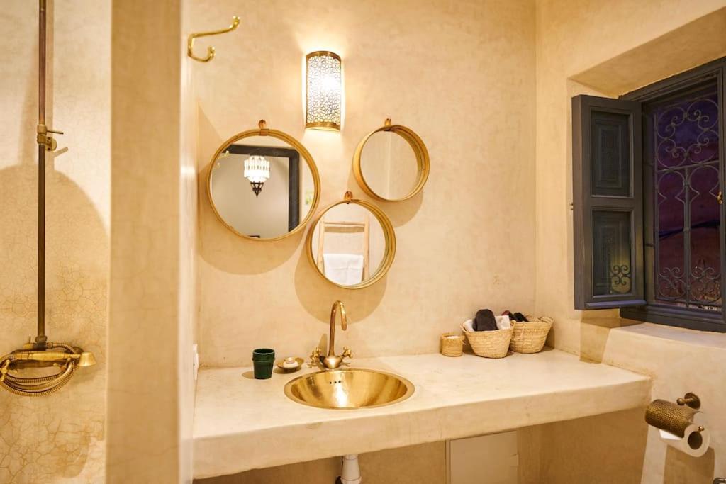 une salle de bain avec un lavabo et deux miroirs dans l'établissement Riad Algora en exclusivité 13 P au cœur de la Médina, à Marrakech