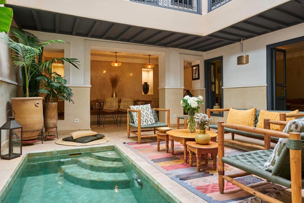 - une piscine au milieu d'une terrasse avec des tables et des chaises dans l'établissement Riad Algora en exclusivité 13 P au cœur de la Médina, à Marrakech