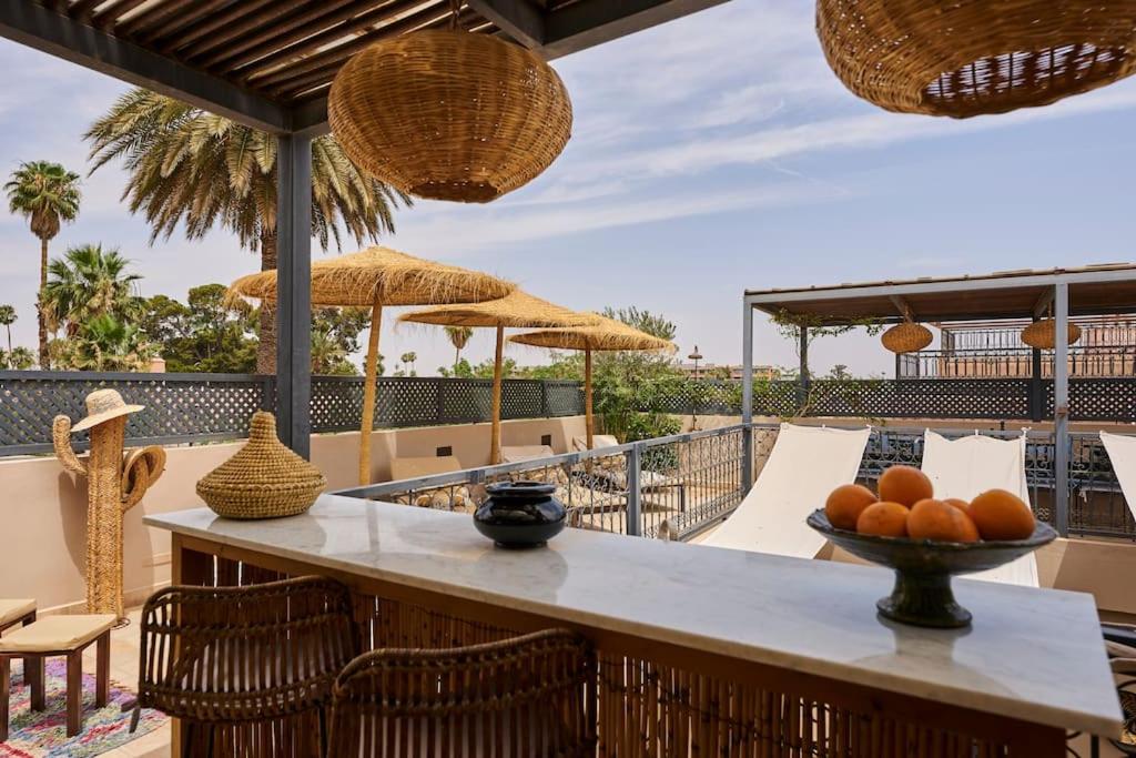 un patio avec une table, des chaises et des parasols dans l'établissement Riad Algora en exclusivité 13 P au cœur de la Médina, à Marrakech