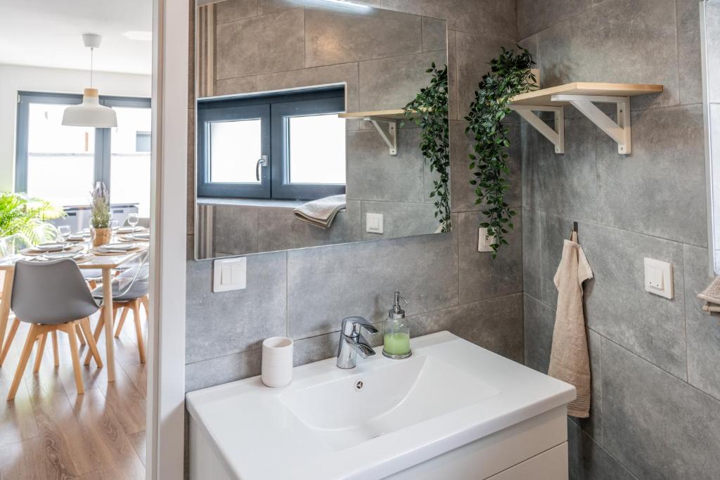 La salle de bains est pourvue d'un lavabo blanc et d'une table. dans l'établissement Appartement l'Eden, à Horbourg-Wihr