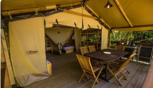 une tente avec une table et des chaises sur une terrasse dans l'établissement Lodge Bois et Toile avec Vue, à Doussard