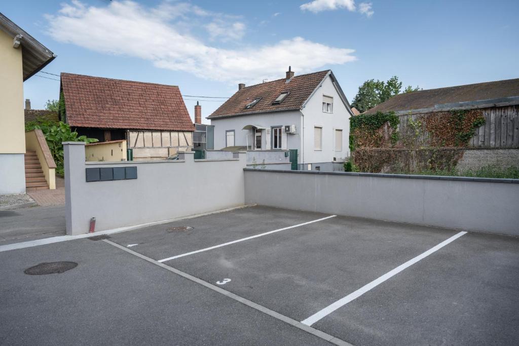 - un parking en face d'une maison blanche dans l'établissement Appartement l'Eden, à Horbourg-Wihr