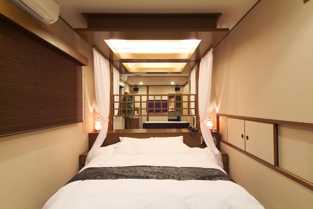 un grand lit dans une chambre avec une fenêtre dans l'établissement hotelLUANA 18歳未満入場禁止, à Nankoku