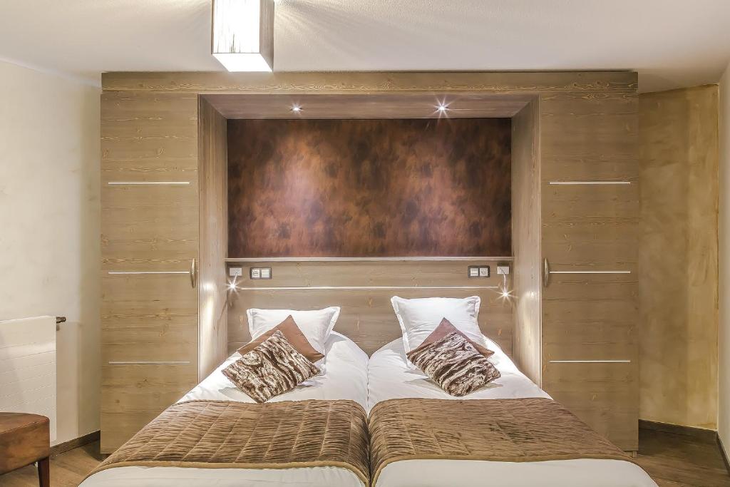 une chambre avec un grand lit avec une tête de lit en bois dans l'établissement Résidence Les Balcons Platinium Val Thorens, à Val Thorens 37 autres photos