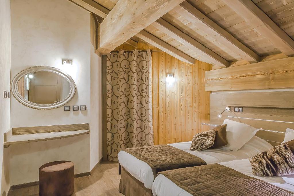 une chambre d'hôtel avec deux lits et un miroir dans l'établissement Résidence Les Balcons Platinium Val Thorens, à Val Thorens