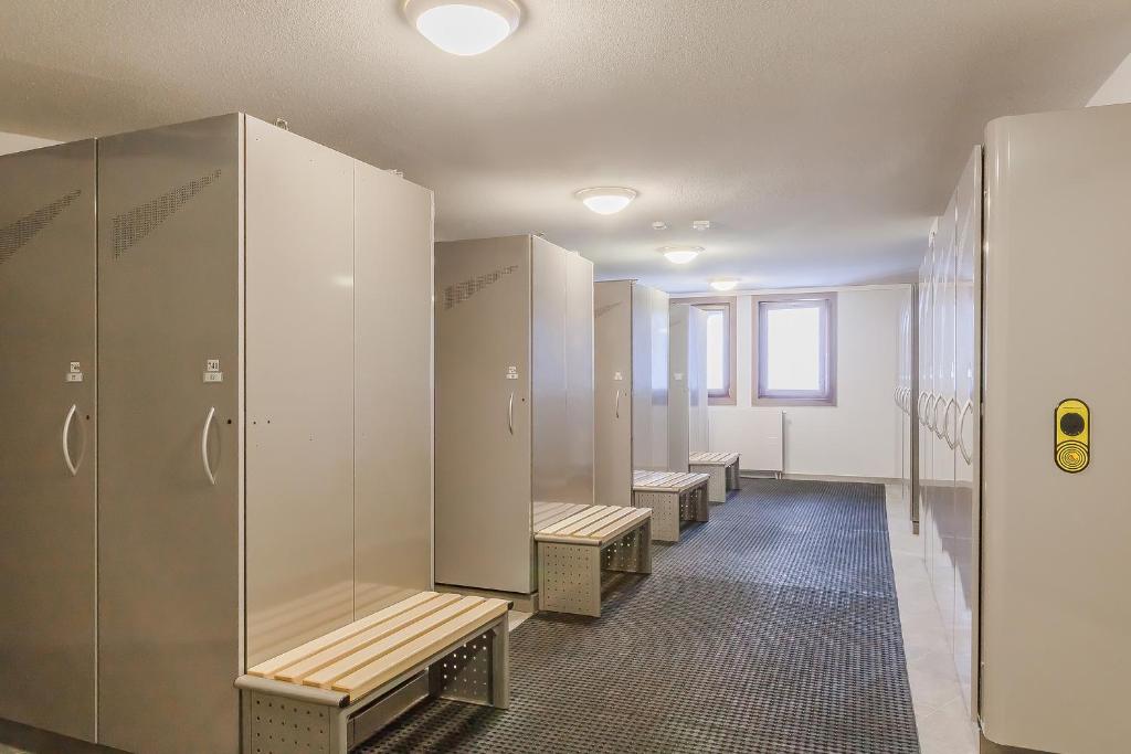 une rangée de bancs dans un vestiaire dans l'établissement Résidence Les Balcons Platinium Val Thorens, à Val Thorens