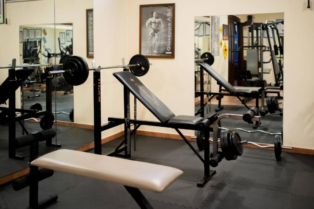 une salle de sport avec plusieurs tapis de course et autres équipements dans l'établissement Villa Egadi, with swimming pool and tennis court, à Paceco
