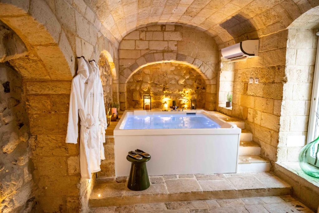 - une salle de bains avec baignoire dans un bâtiment en pierre dans l'établissement Vecchia Mottola WELLNESS, à Mottola