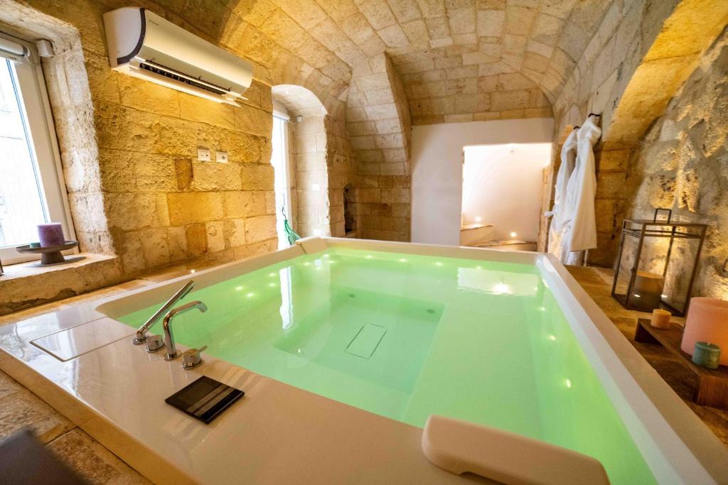une grande salle de bain avec une grande baignoire dans un immeuble dans l'établissement Vecchia Mottola WELLNESS, à Mottola
