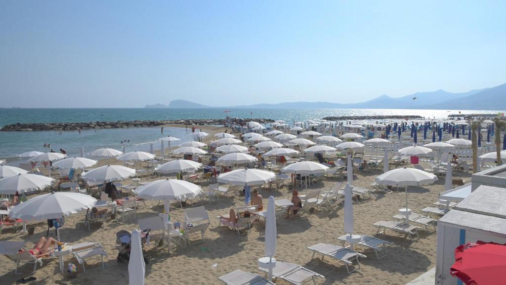 - une plage avec de nombreux parasols blancs et l'océan dans l'établissement BAJAMAR BEACH HOTEL, à Formia