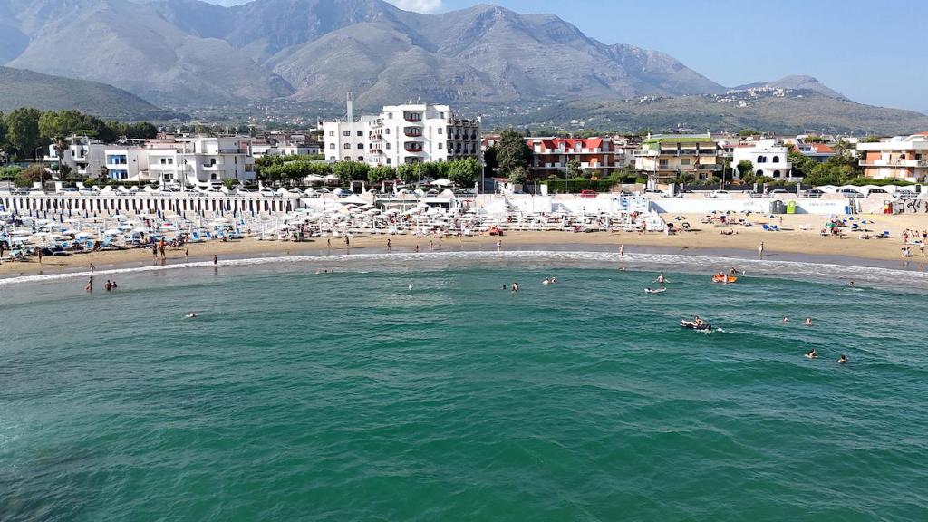 un groupe de personnes dans l'eau sur une plage dans l'établissement BAJAMAR BEACH HOTEL, à Formia