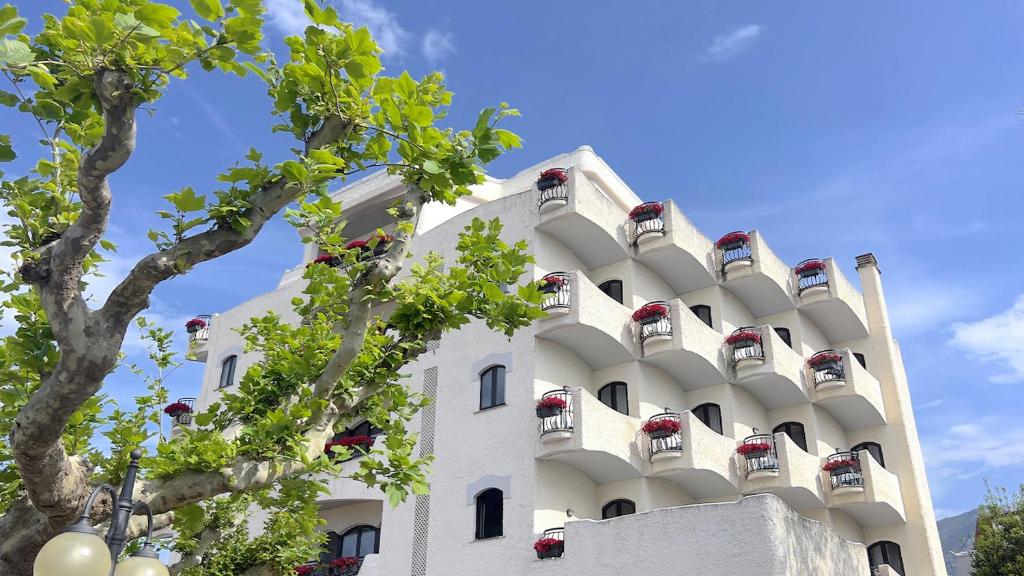 un bâtiment blanc avec des jardinières dessus dans l'établissement BAJAMAR BEACH HOTEL, à Formia