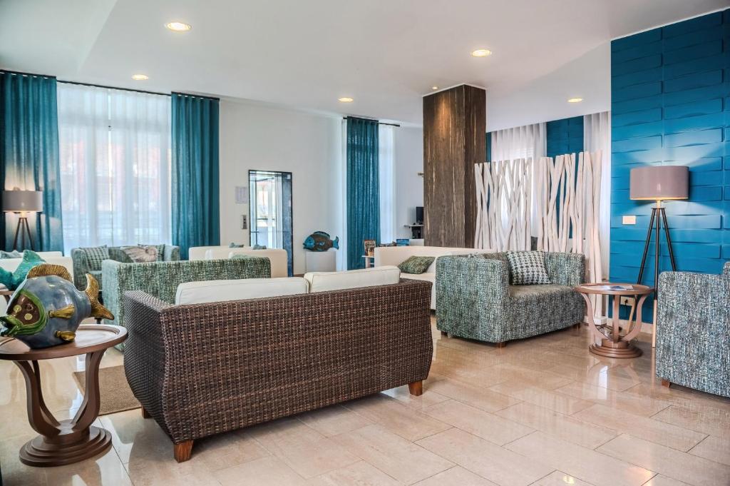 - un salon avec des canapés et des chaises dans l'établissement Hotel Orizzonte, à Lido di Jesolo