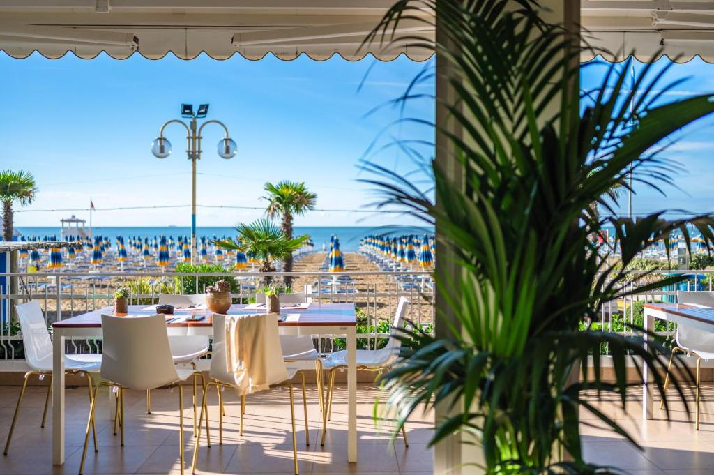 d'une terrasse avec tables et chaises et vue sur la plage. dans l'établissement Hotel Orizzonte, à Lido di Jesolo