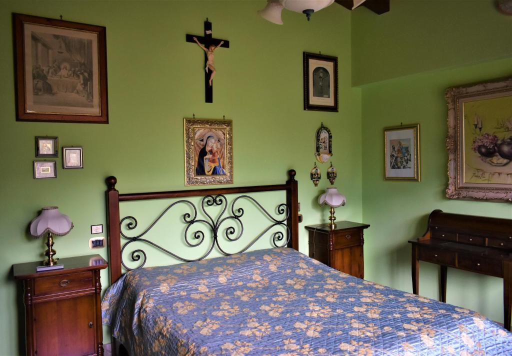 - une chambre avec un lit et une croix sur le mur dans l'établissement Villa Caterina, à Torretta