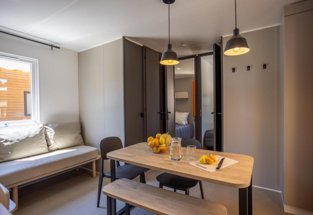 une salle à manger avec une table et un canapé dans l'établissement Camping maeva Escapades Le Hameau des Pins, à La Crau