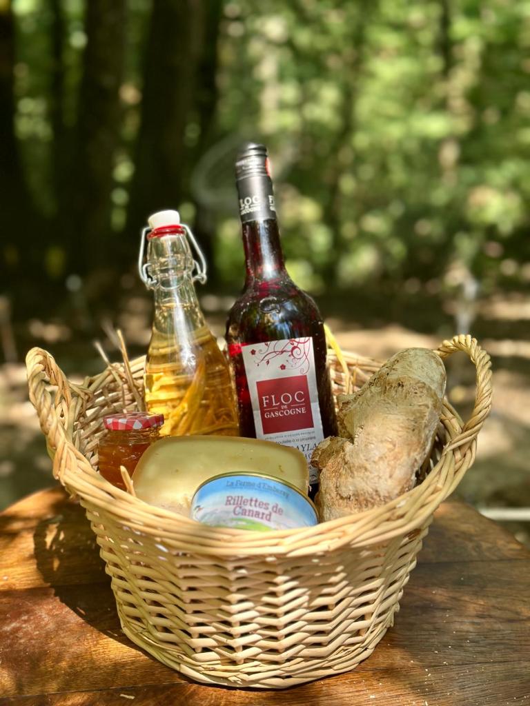 un panier de pique-nique avec une bouteille de bière et des légumes dans l'établissement Wild Lodge, à Lasséran
