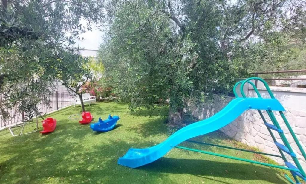 - une aire de jeux avec un toboggan bleu dans la cour dans l'établissement Eco Charming Puglia Villa Simone, à Foggia