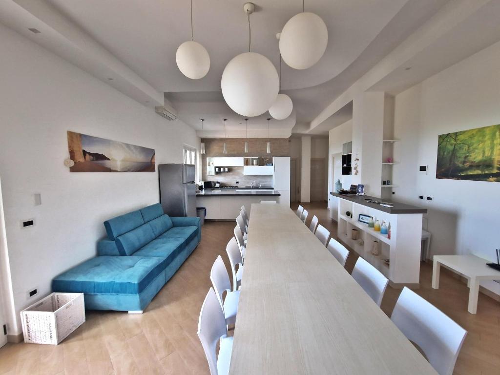 - un salon avec une grande table et un canapé bleu dans l'établissement Eco Charming Puglia Villa Simone, à Foggia