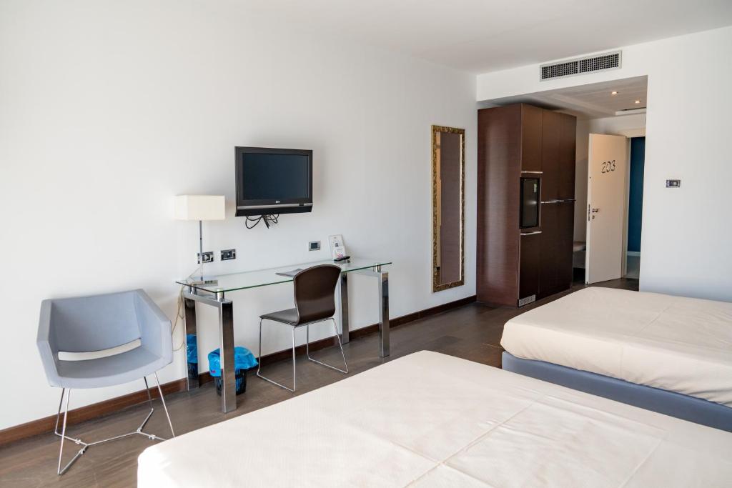 une chambre d'hôtel avec un bureau et un lit dans l'établissement Hotel Napoleon, à Torre Melissa