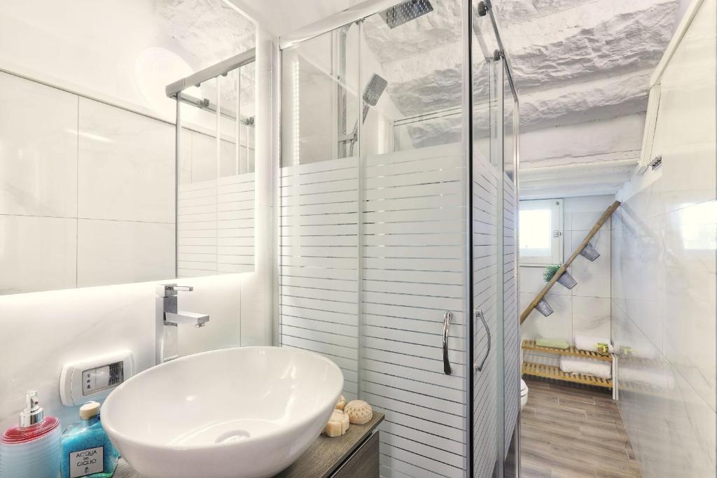 une salle de bain blanche avec un lavabo et une douche dans l'établissement Villa Orsini Peccioli - Villa storica ad uso esclusivo con piscina, à Peccioli