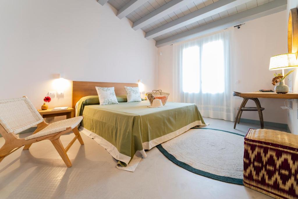 une chambre avec un lit, une chaise et une fenêtre dans l'établissement Planeta Country House & Beach Club, à Menfi