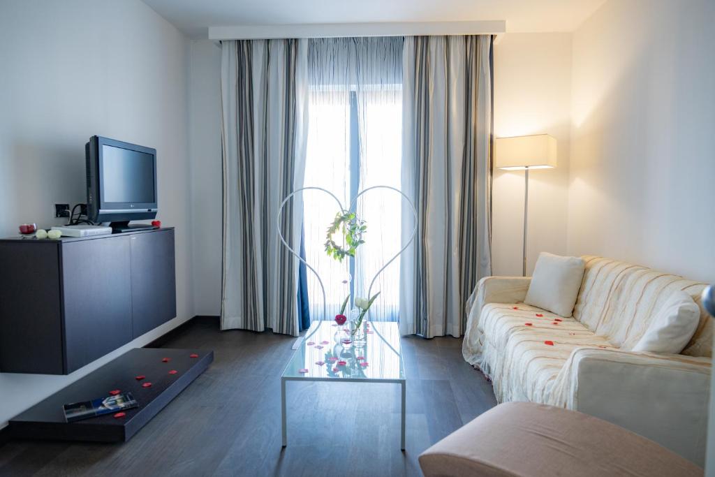 un salon avec un canapé et une télévision dans l'établissement Hotel Napoleon, à Torre Melissa